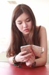 Portrait Of Thai Adult Beautiful Girl Using Her Smart Phone And Smile Stock Photo