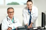 Smiling Doctor Typing On Keyboard Stock Photo