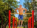 Young Man Is Practicing On A Horizontal Bar Stock Photo