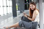 Portrait Of Thai Adult Beautiful Girl Using Her Tablet And Smile In University Stock Photo