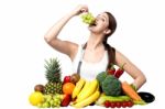 Young Smiling Girl Eating Grapes, Looking At Camera Stock Photo