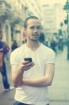 Young Man With Cell Phone Walking Stock Photo