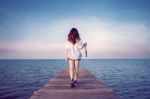 Woman Walking On Wooden Bridge Extended Into The Sea. (vintage Color) Stock Photo