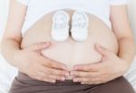 Pregnant Belly With A Pair Of White Shoes Stock Photo