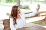 Portrait Of A Young Woman Taking A Picture With Her Cell Phone Stock Photo