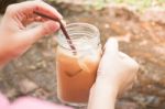 Hand On Glass Of Iced Milk Coffee With Vintage Filter Effect Stock Photo