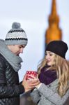 Young Couple In Love Embracing And Drinking Hot Drink From Red C Stock Photo