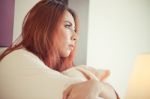 Sad Woman Sitting On The Bed Stock Photo