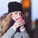 Attractive Young Stylish Blonde Girl Drinks Hot Drink From A Mug Stock Photo