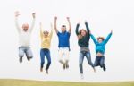 Family Jumping On The Air At Park Stock Photo