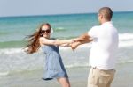 Young Couple Playing On Beach Stock Photo