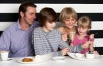 Family Enjoying Breakfast At A Restaurant Stock Photo