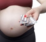 Pregnant Woman Holding Pills Stock Photo