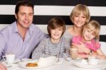 Family Enjoying Breakfast At Restaurant Stock Photo