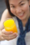 Close Up A Glass Of Orange Juice In Hand Of Young Woman Stock Photo