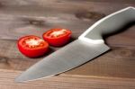 Fresh Cut Tomatoes With Knife On The Dark Wooden Table Stock Photo