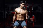 Young Man Doing Heavy Weight Exercise In Gym Stock Photo