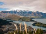 Snowy Mountain Range With A Town And Lake Stock Photo