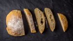 Sliced Ciabatta On The Dark Stone Table Top View Stock Photo