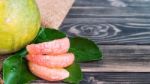 Fresh Grapefruit And Grapefruit Leaves On Black Wood Stock Photo