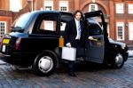 Corporate Man Stepping Out Of A Cab Stock Photo