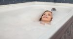 Little Girl Lying In A Bathtub Stock Photo