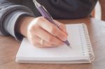 Woman Hand With Pen Writing On Notebook Stock Photo