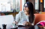 Young Beautiful Woman Using Her Mobile Phone In Coffee Stock Photo