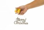 One Hand Holding Yellow Gift Box And Merry Christmas Sign Stock Photo