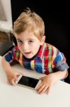 Little Boy Plays With Smartphone Stock Photo