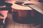 Guitar With Red Book And Pen On A Wooden Table, Vintage Style Stock Photo