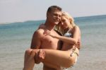 Man Holding Woman At Beach Stock Photo