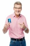 Senior Man Showing And Pointing Debit Card Stock Photo