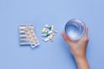 Hand Holding Glass Of Water With Pills Stock Photo