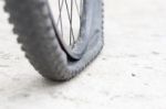 Bicycle Wheel With Flat Tyre On The Concrete Road Stock Photo