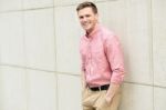 Young Man Posing Smartly Against Wall Stock Photo