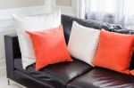 Orange And White Pillows On Modern Black Sofa In Stock Photo