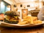 Black Burger With French Fries In Cafe Stock Photo