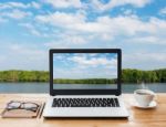 Laptop Computer And Coffee On Wood Workspace And Mangrove Forest Background Stock Photo