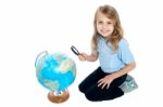 Girl Watching Globe Through Magnifying Glass Stock Photo