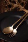 Black Empty Plate Fork Spoon On Wooden Table Background Stock Photo