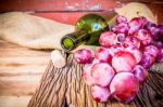 Bottle Of Red Wine, Grape And Corks On Wooden Table Stock Photo