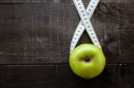 An Apple Surrounded By A Measuring Tape Tailor On Wood Stock Photo