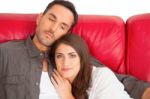 Beautiful Woman With Boyfriend Relaxing On Sofa Stock Photo