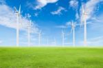 Wind Turbine On Green Grass With Blue Sky Stock Photo