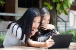 Two Asia Thai High School Student Best Friends Beautiful Girl Using Her Tablet And Funny Stock Photo