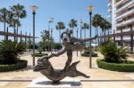 Man Above Dolphin Statue By Salvador Dali In Marbella Stock Photo