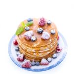 Pile Of Pancakes With Blueberries And Raspberries Sprinkled With Stock Photo