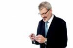 Senior Businessman Reading A Text Message Stock Photo