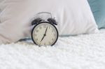 Modern Black Alarm Clock On Bed Stock Photo